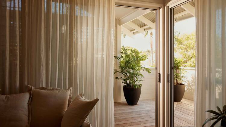 A hotel room looking out onto a balcony. 