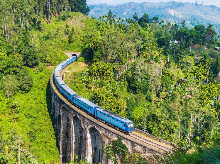 Blue train on Nine Arches bridge near Ella in Sri Lanka