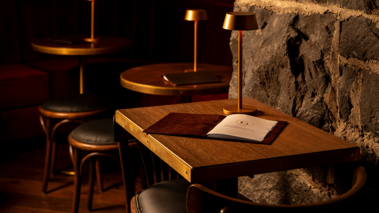 A table and chairs nestled by a bluestone wall at Miss Gunn's.