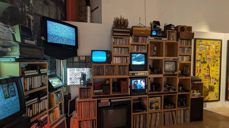 TVs displaying static stacked on top of bookcases at Mick Jones’s Rock & Roll Public Library