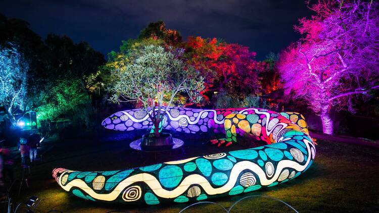 A giant glowing colourful snake sculpture. 