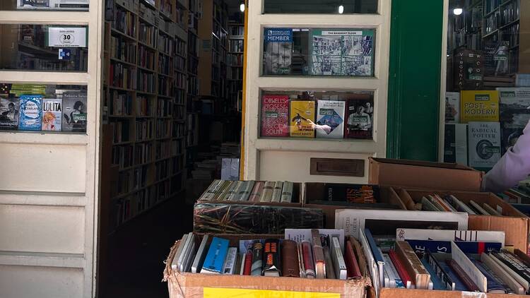 Cardboard boxes filled with used books sit outside Judd Books in Bloomsbury. The boxes have yellow labels on them saying 'All books £1.95 and under or 3 for £4.50'