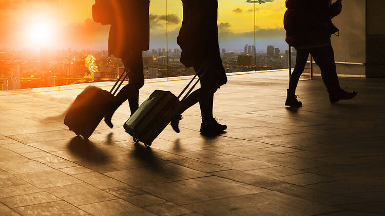 People pulling a suitcase in an airport