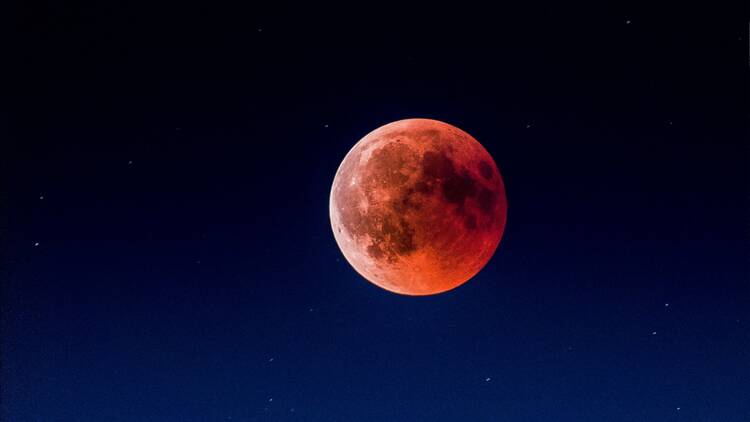 A red-tinged moon in the night sky