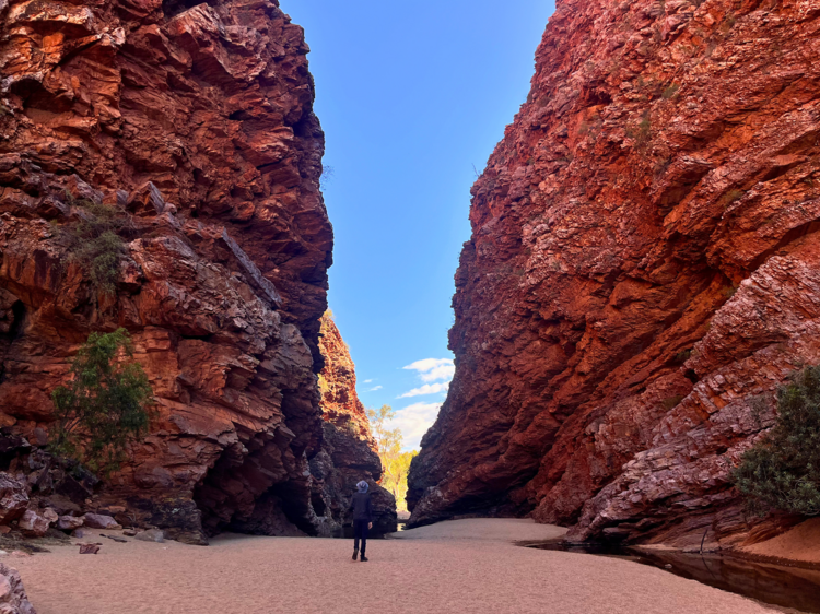 Man gazing up at large rocks divided into two