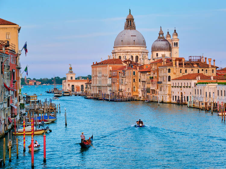 View of Venice Grand Canal with boats and Santa Maria della Salute church on sunset from Ponte dell'Accademia bridge. Venice, Italy