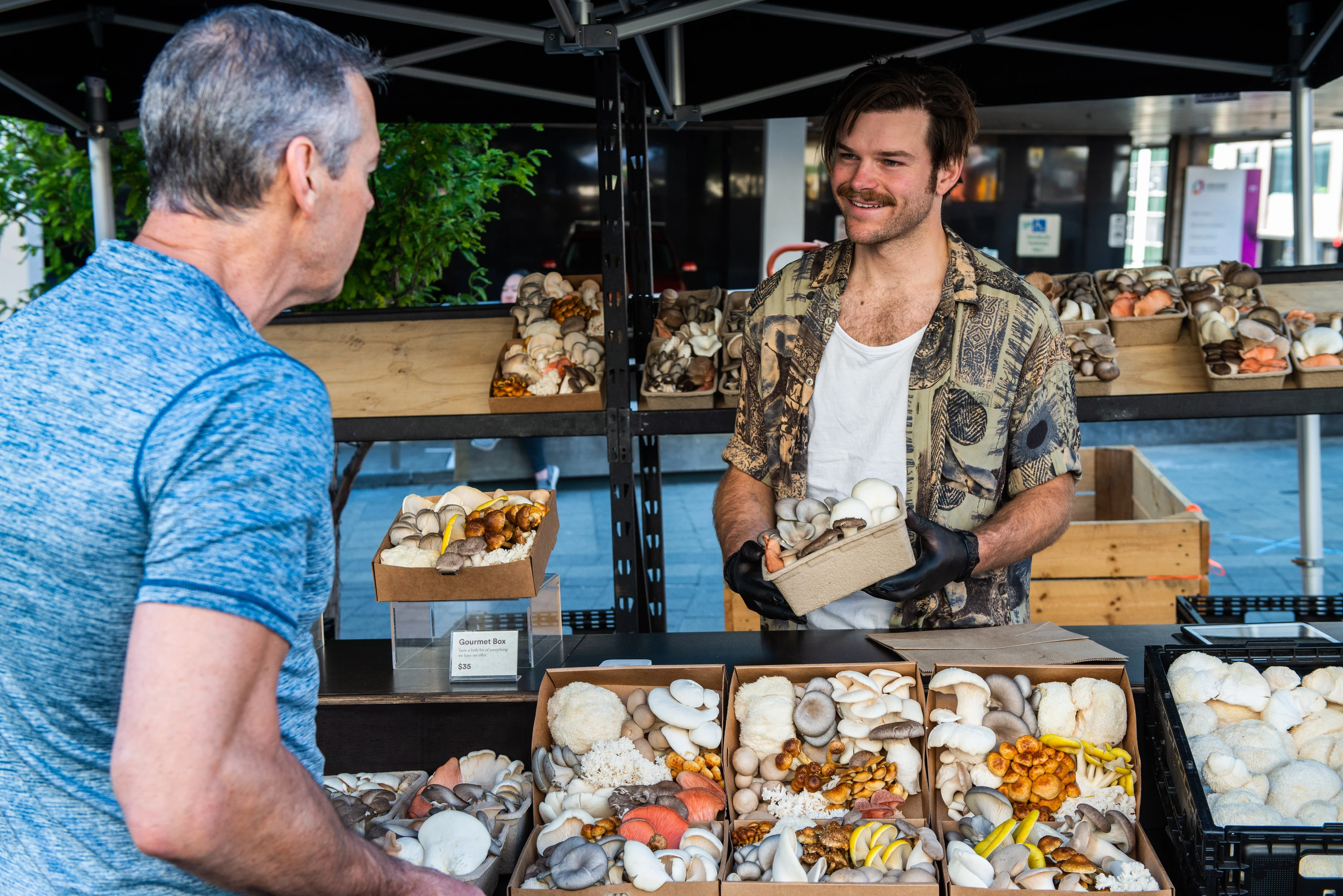 Mushroom man selling produce at market stall