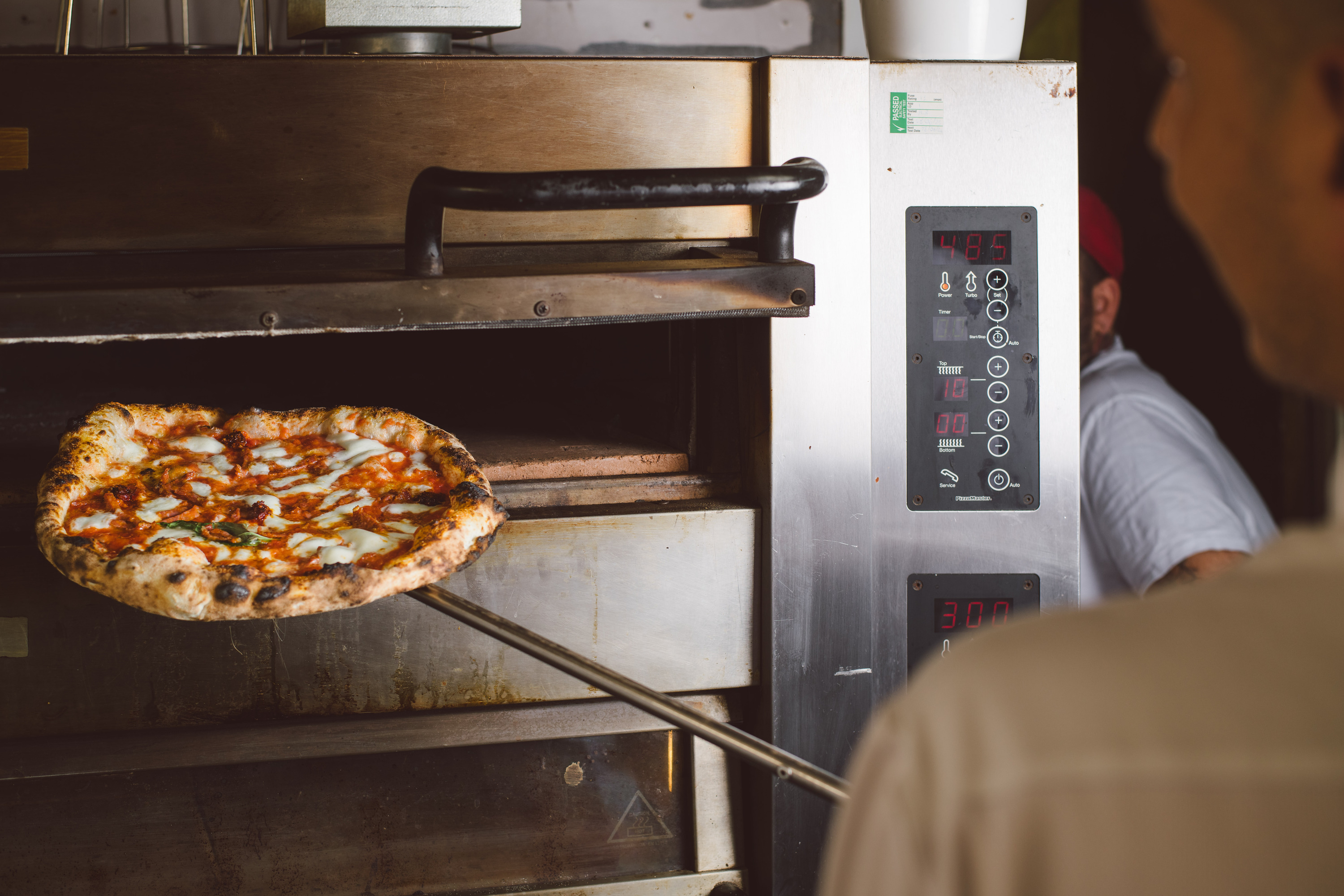 Pizza going into a pizza oven 