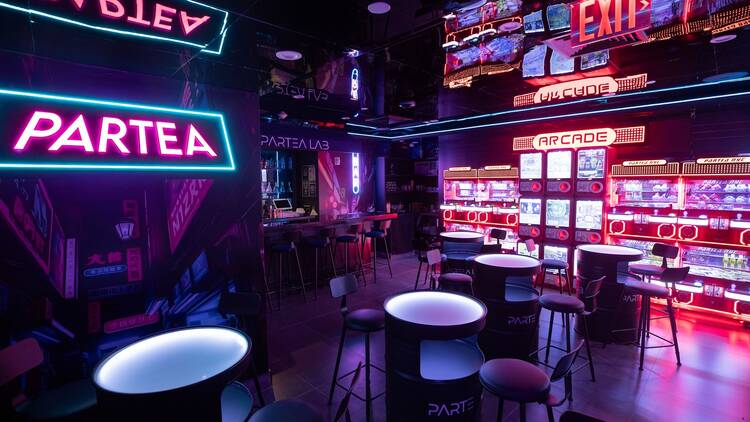 A neon-lit bar with an arcade inside