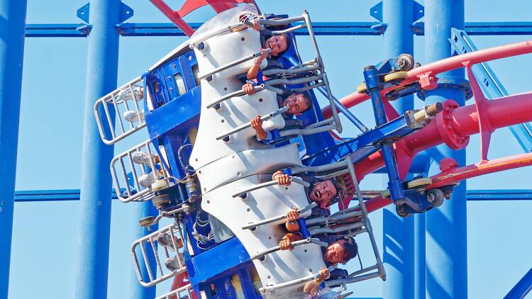 Four people on a roller coaster making silly faces.