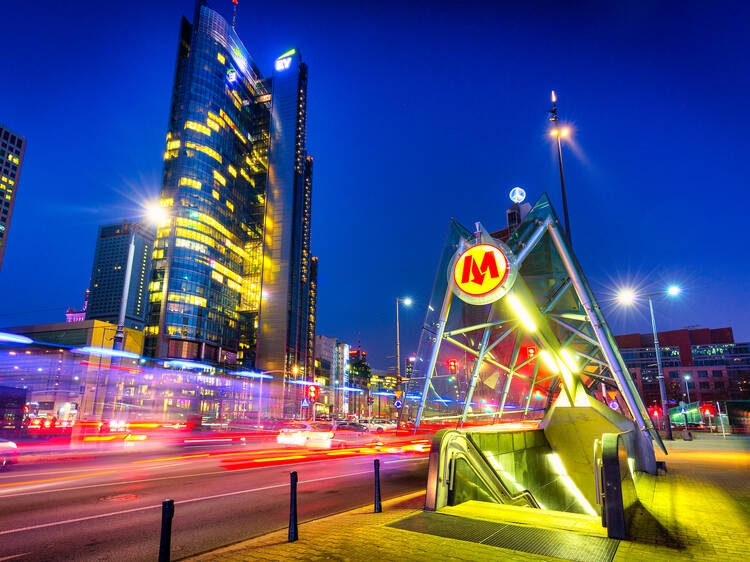 Amazing cityscape of Warsaw with metro station entrance by night, capital of Poland.