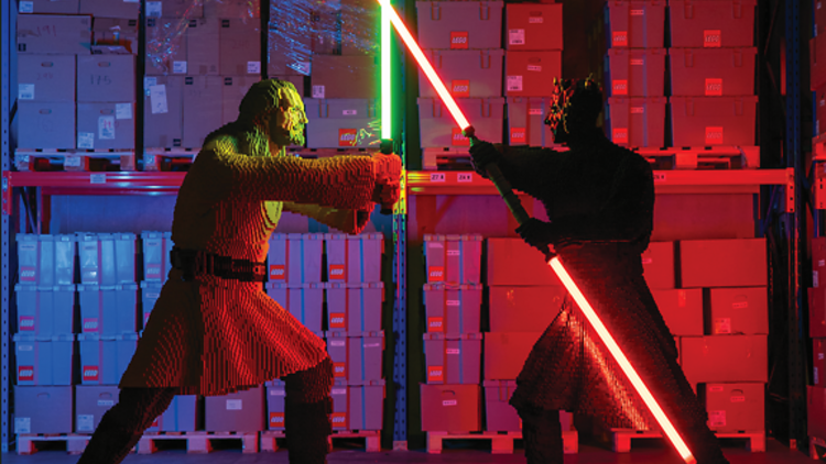 Two Star Wars characters built in Lego with lightsabers