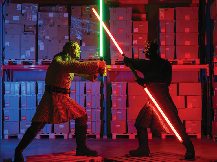 Two Star Wars characters built in Lego with lightsabers