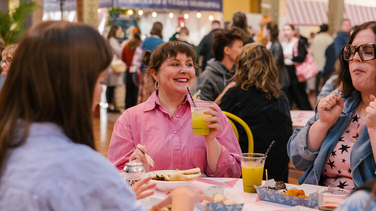 People sitting at a table drinking and eating. 