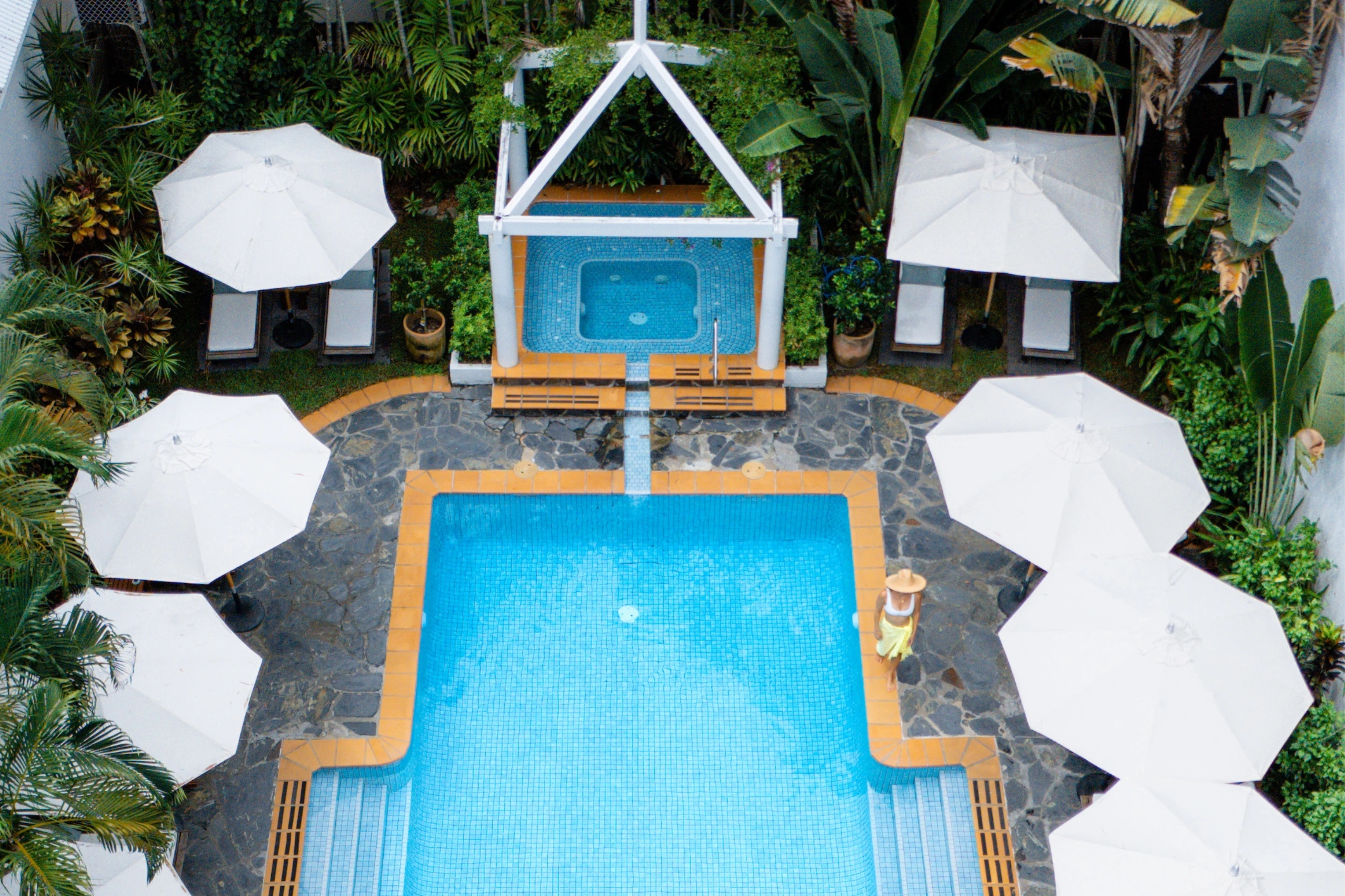 Aerial view of pool with white umbrellas