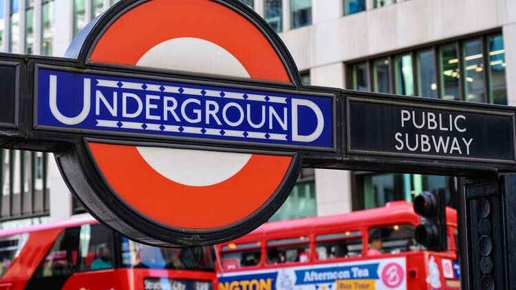 London Underground sign with buses in the background, London