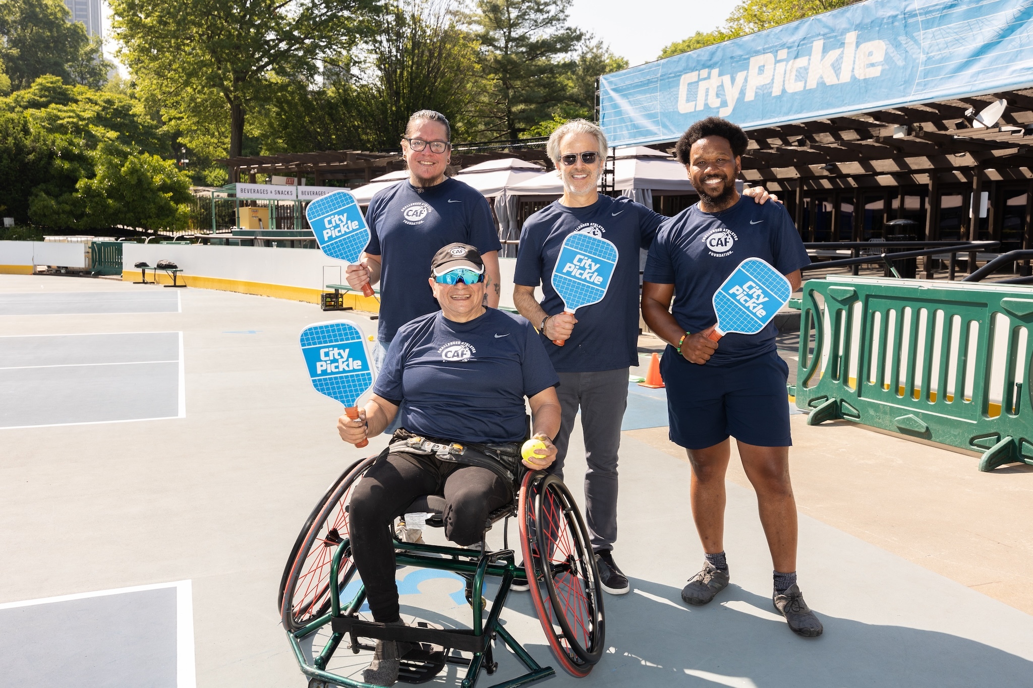 Challenged Athletes Foundation players at Wollman Rink, showing several men holding pickleball paddles.