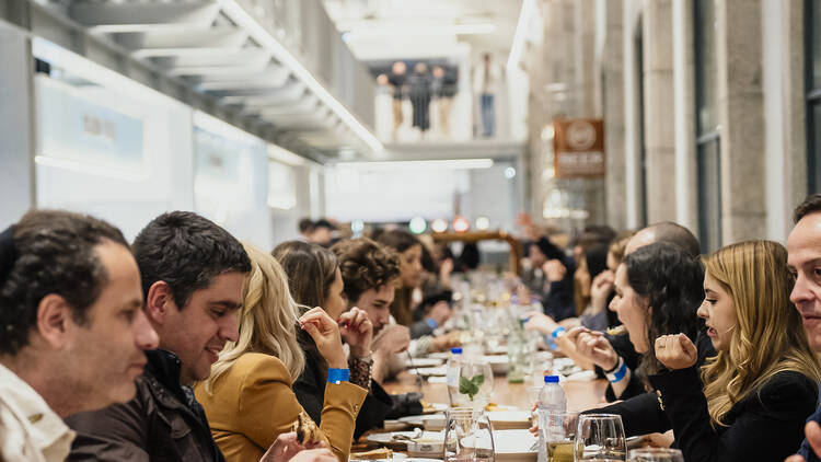 Picture of a long table at Time Out Market Porto full of food and people