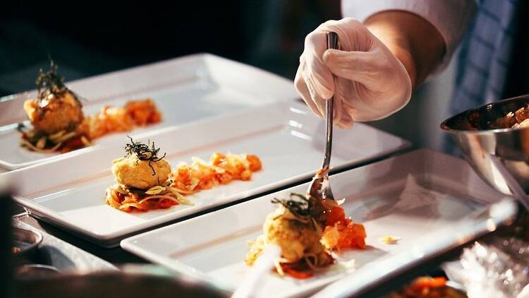 hand spooning topping onto an appetizer