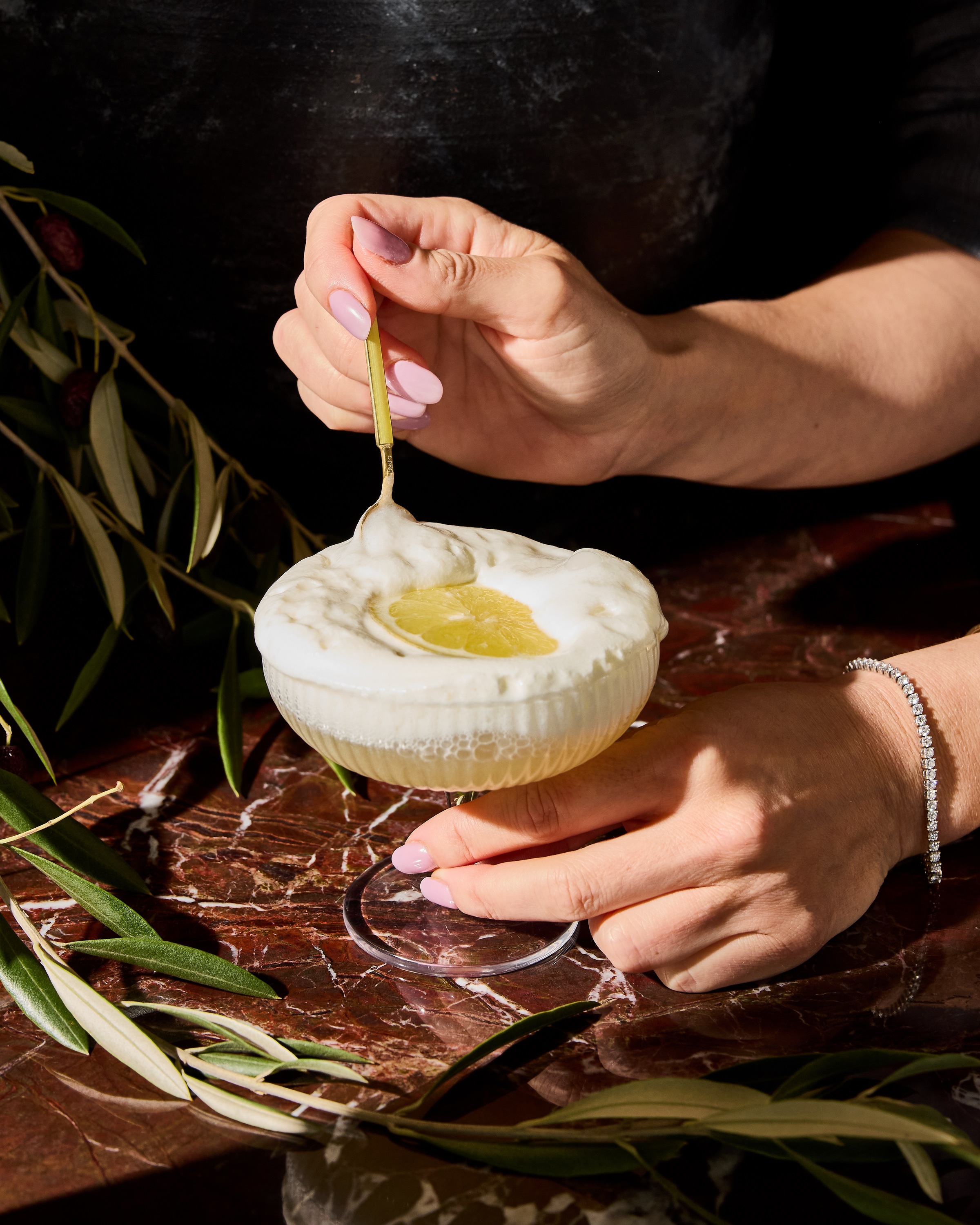 Frozen Sgroppino a yellow cocktail with white sorbert on the top with a lemon