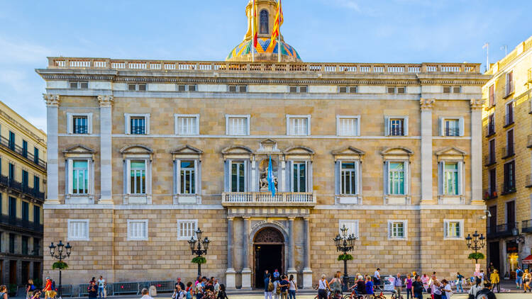 People are walking in front of the Palau de la generalitat on the plaza sant jaume in Barcelona, Spain.