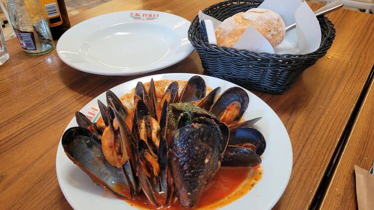 Mussels in red sauce in a white bowl