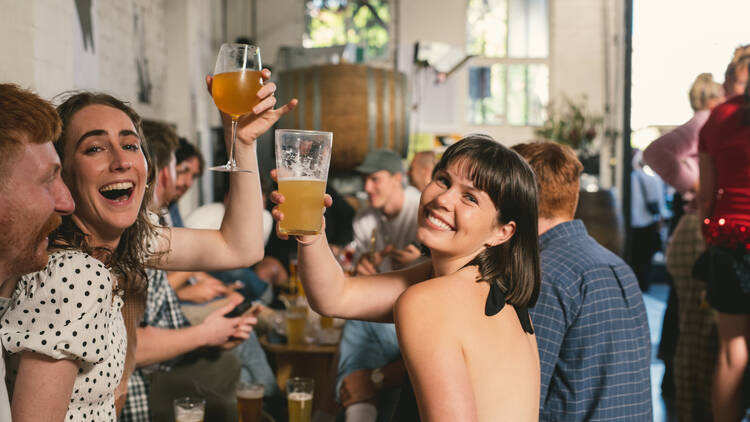 Woman smiling with beer and her friends.