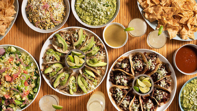 A table of tacos, esquites, guacamole and margaritas