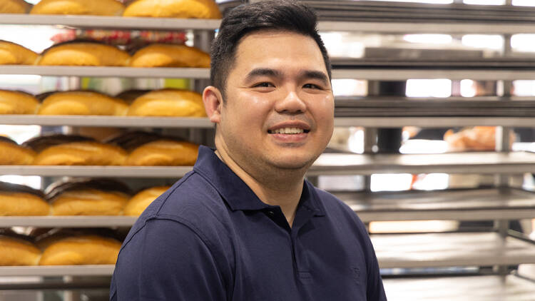 Luke Vu smiling for the camera in his bakery.