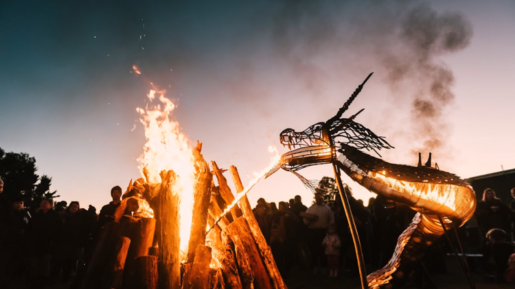 A fire-breathing dragon sculpture next to a bonfire at the East Gippsland Winter Festival.