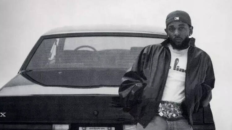 Kendrick Lamar posing on car