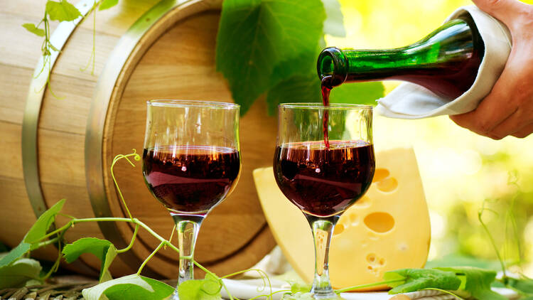 A stock photo of someone pouring red wine into a glass