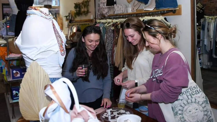 three women smiling down at a table of things three women smiling down at a table of things