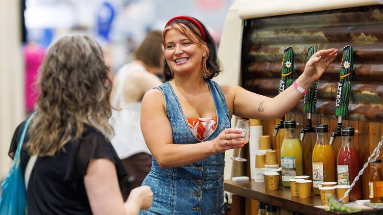 A woman pouring drinks at the Good Food and Wine Show.