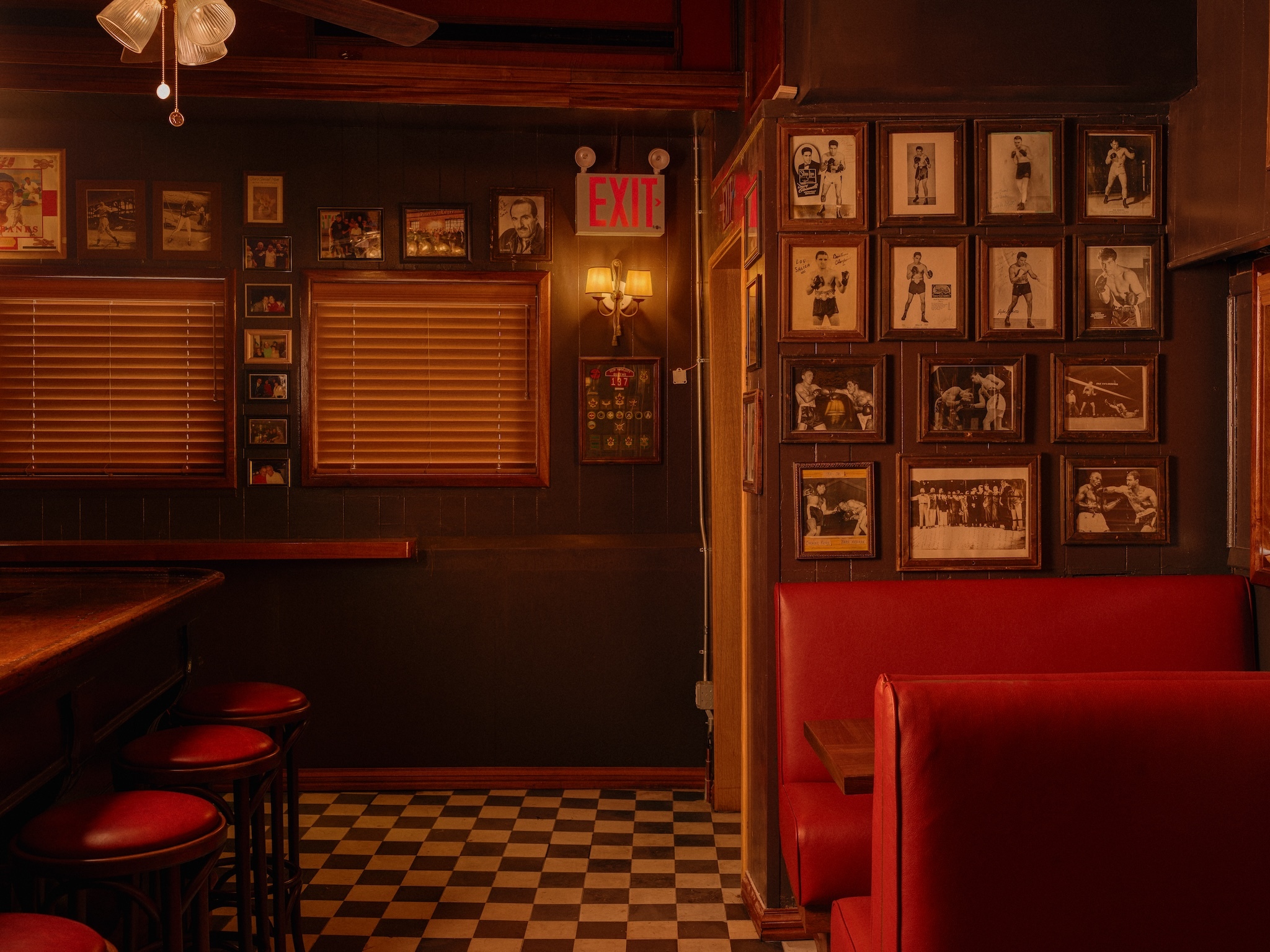 | Black and white images of boxing memorabilia and actors from yesteryear hang on the wall 