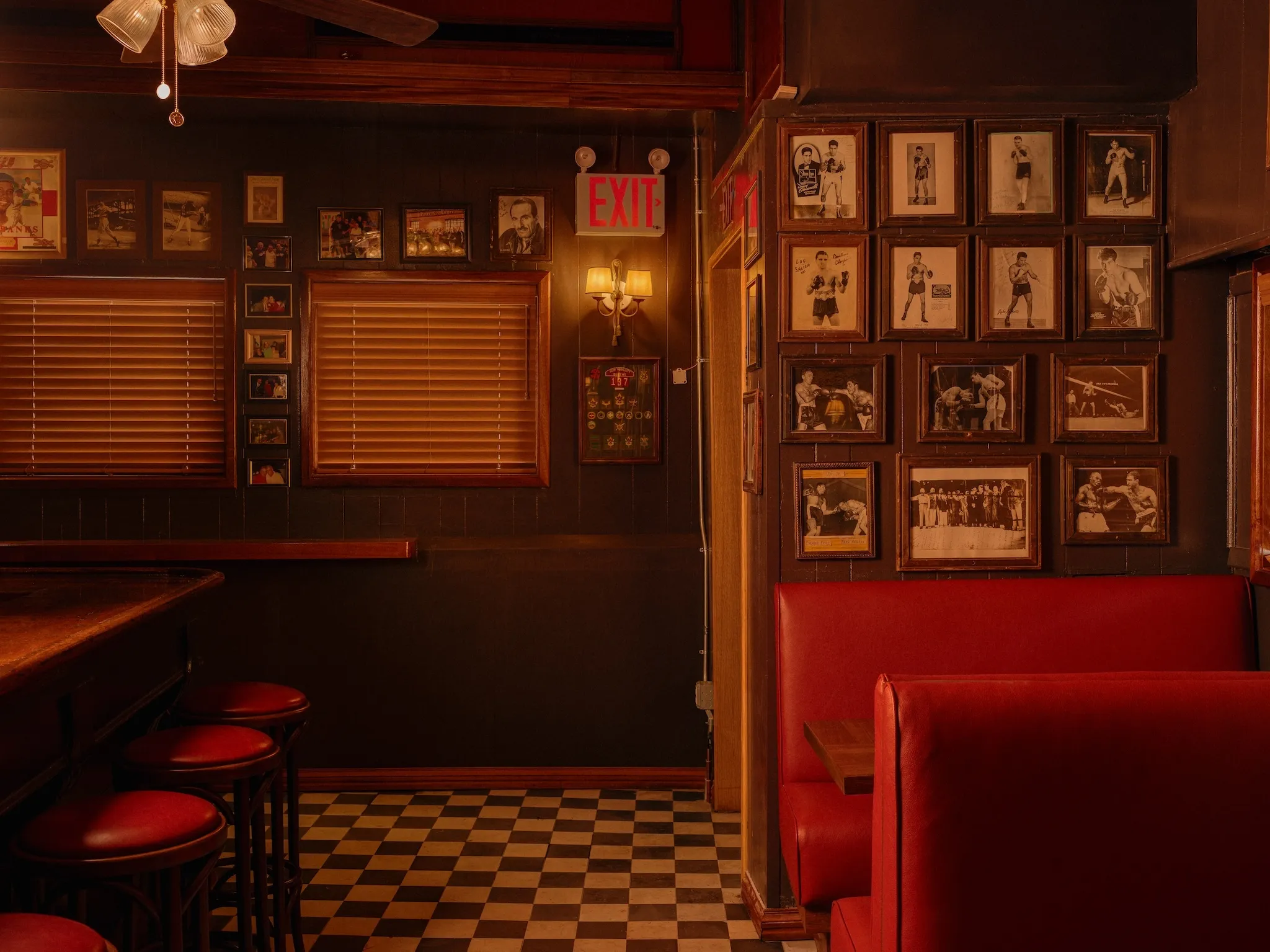 | Black and white images of boxing memorabilia and actors from yesteryear hang on the wall