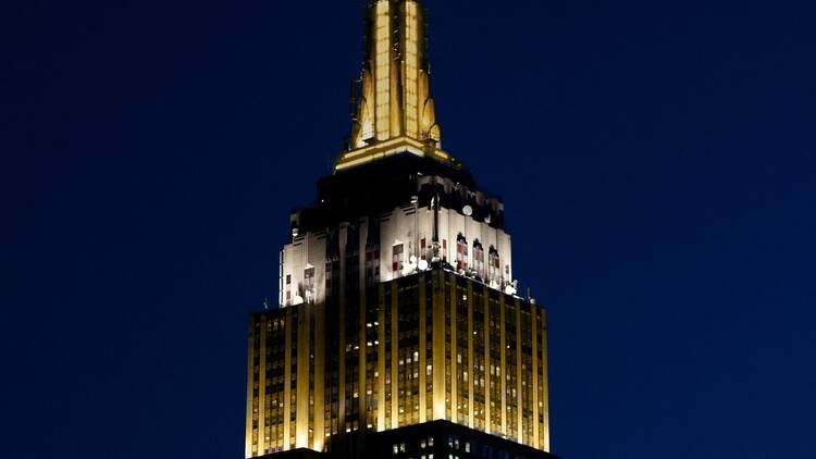 the Empire State Building lit in gold and white