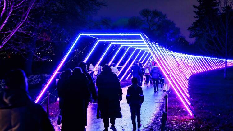 People walking through a tunnel of lights. 