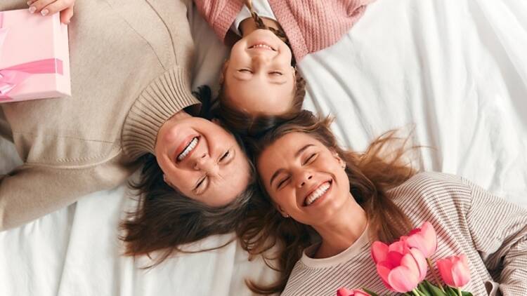 Mother, daughter, grandchild lying down smiling iStock image