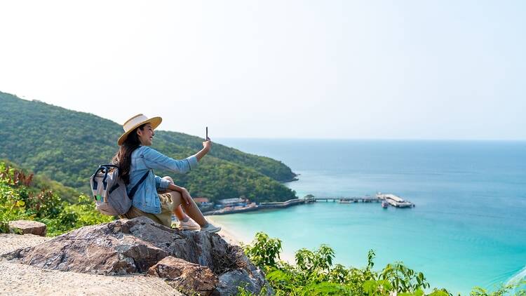 A women with a phone next to the sea
