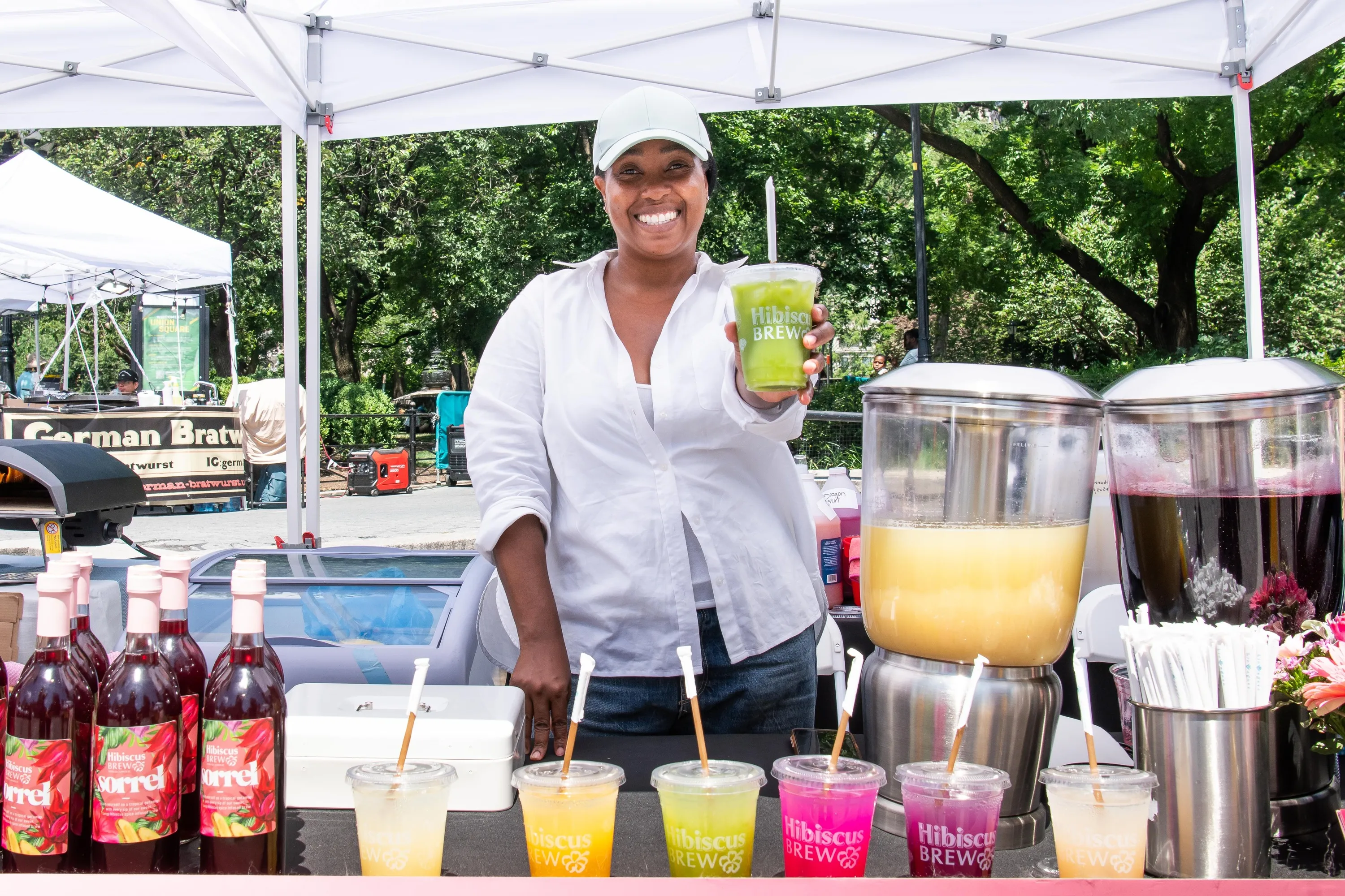 A woman holding a shake with the name "Hibiscus Brew" on it