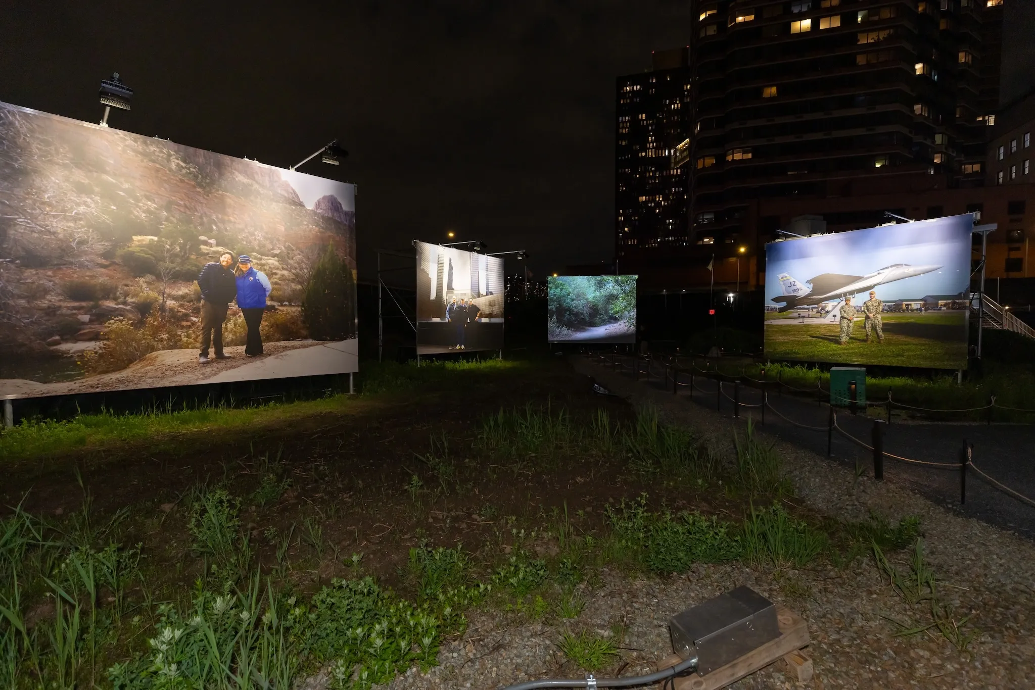 Four large screens with photographs on them are illuminated.