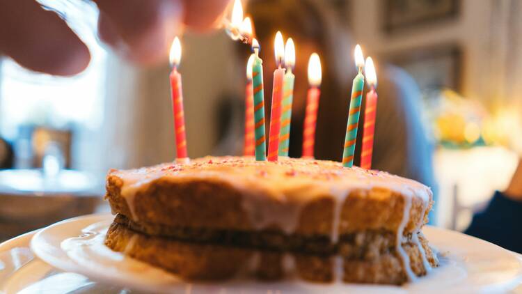 Cake with candles on white plate