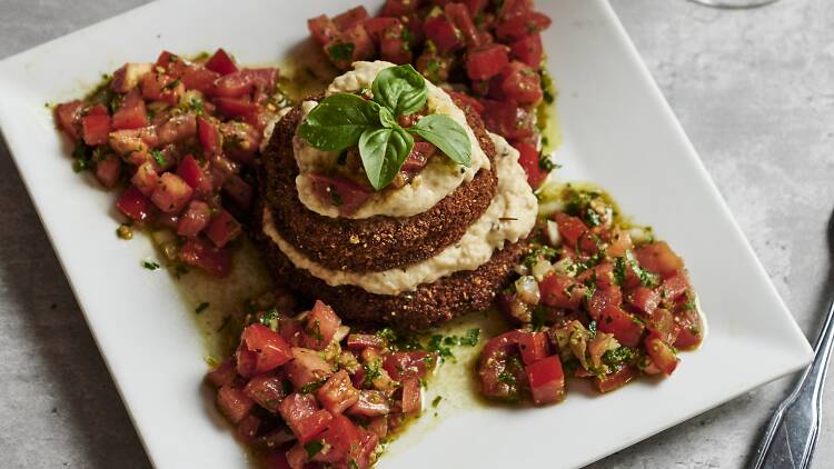 Eggplant Napolean on a white dish on a marble table