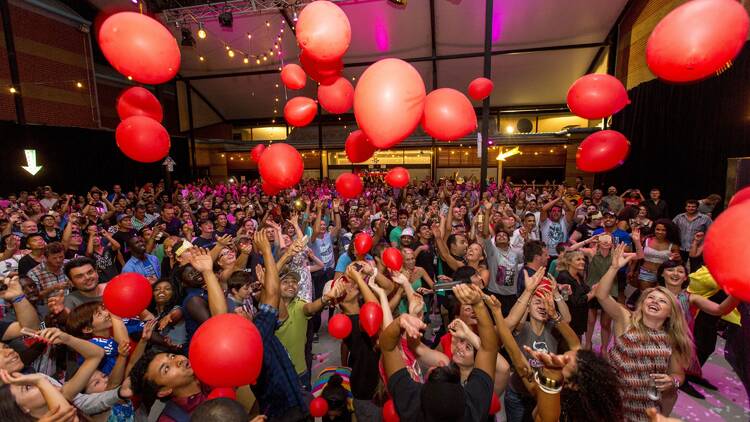People dancing with red balloons