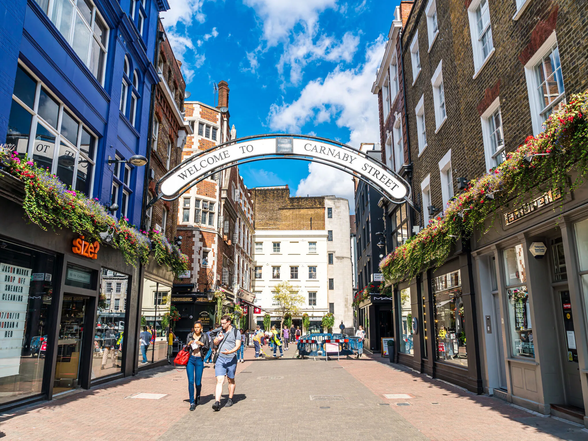 People walking for shopping in Carnaby Street. Carnaby Street is a pedestrianised shopping street in Soho in the City of Westminster, Central London.