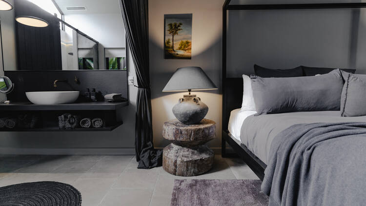 The bed and bathroom of a Studio Room at the Bower in Byron Bay.