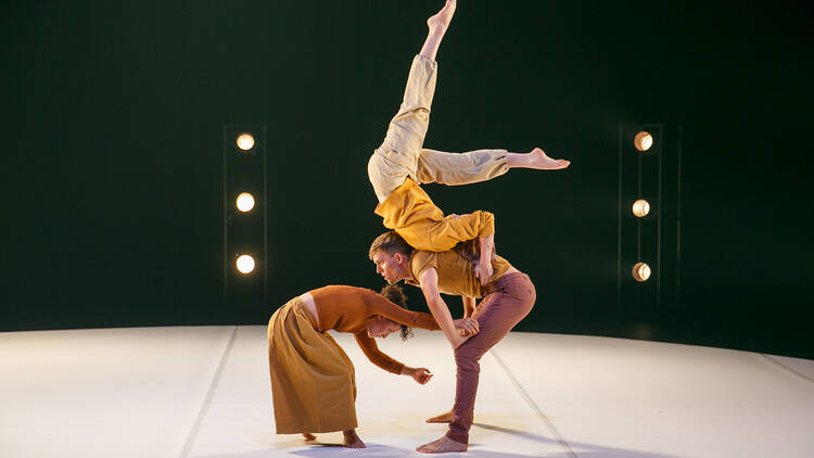 Three circus performers on a stage.