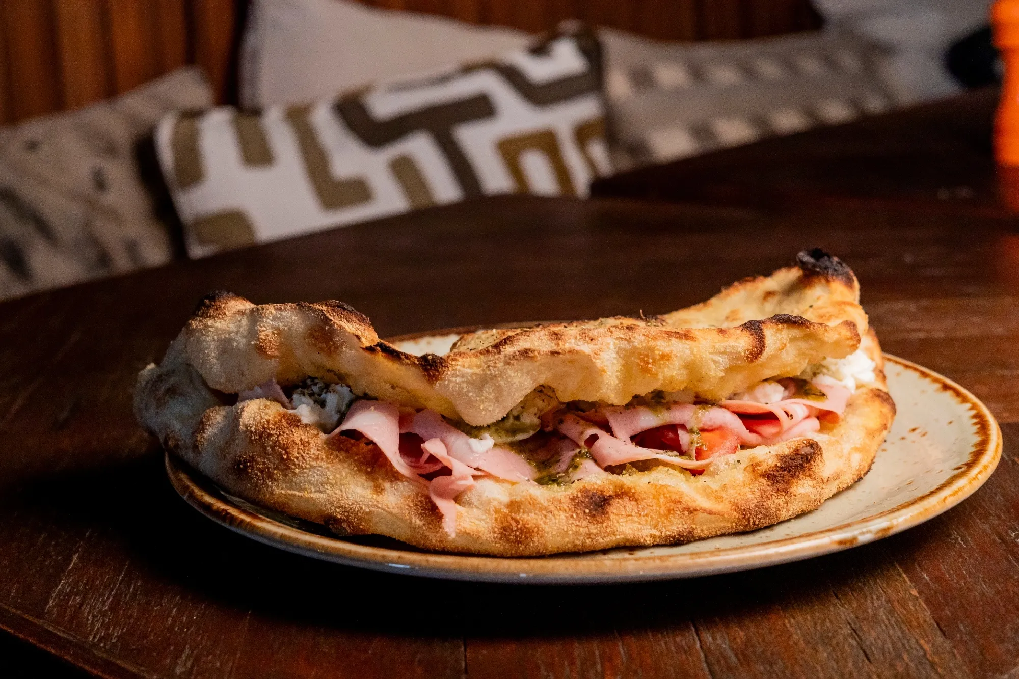 A Pizza Mortazza tem pesto de manjericão, mortadella, queijo burrata, tomate cherry e orégãos
