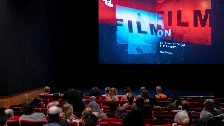 BFI Film on Film festival Audience members sit in cinema auditorium in front of a screen showing the logo for the BFI’s Film on Film festival